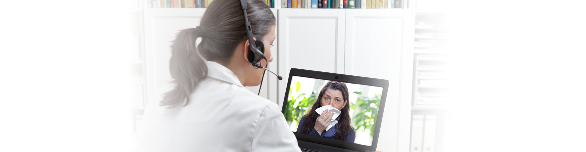 a psychiatrist talking to his patient on a laptop